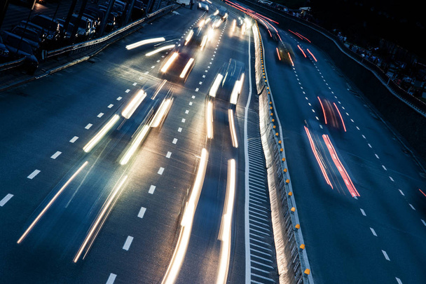 die Lichtspuren des Autos auf der Autobahn in der nächtlichen modernen Stadt - Foto, Bild