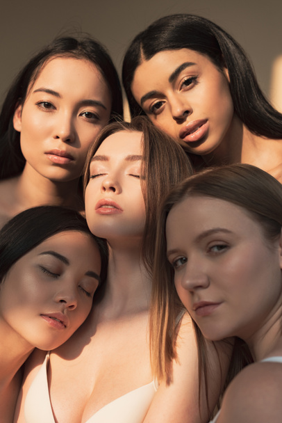 cinque ragazze multiculturali sognanti in posa alla fotocamera alla luce del sole
  - Foto, immagini