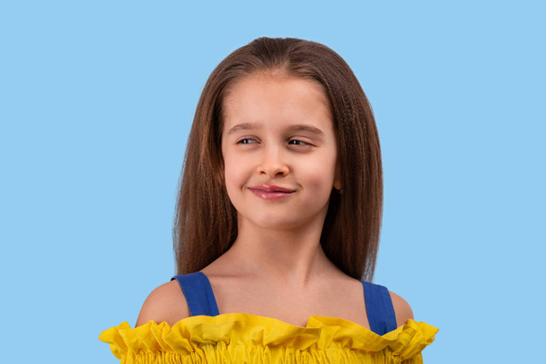 Студийный снимок молодой девушки в жёлтом сарафане на синем
  - Фото, изображение