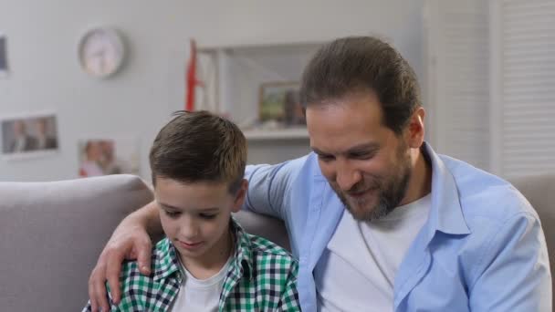 Father and little son spending time together, playing games on smartphone, wifi - Materiał filmowy, wideo
