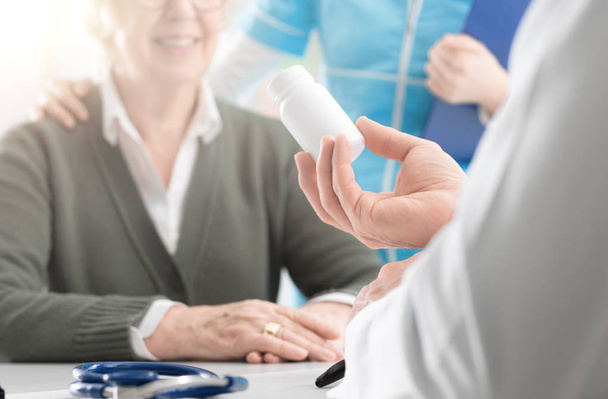 Επαγγελματίας γιατρός δίνει ένα συνταγογραφούμενο φάρμακο σε ένα ανώτερο p - Φωτογραφία, εικόνα