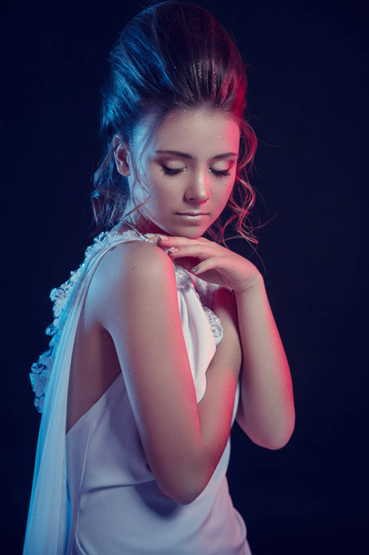 Mode portret van elegante meisje in witte jurk. Zwarte achtergrond, studio opname. - Foto, afbeelding