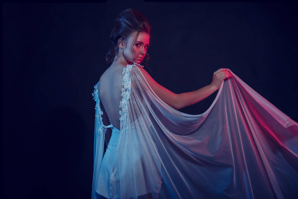 Модный портрет молодой элегантной девушки в белом платье. Черный фон, студийный снимок
. - Фото, изображение