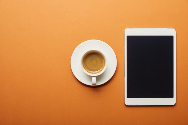 top view of digital tablet with blank screen near cup of coffee on orange  - Photo, Image