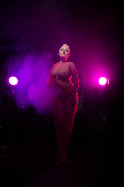 sexy paffuto donna capelli corti in biancheria intima trasparente vestiti su sfondo scuro fumo con luci
 - Foto, immagini