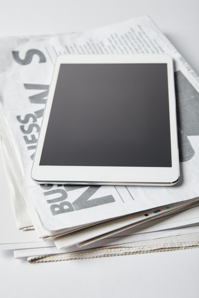 digital tablet with blank screen on business newspapers on white  - Fotó, kép