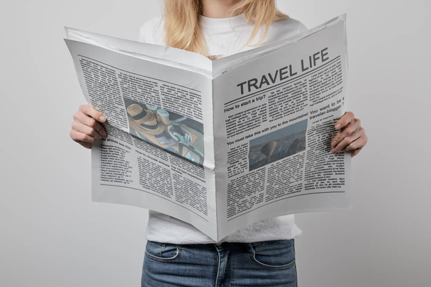 グレーに分離された旅行新聞を保持している女性のトリミング ビュー  - 写真・画像
