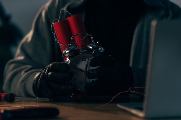 Partial view of criminal in leather gloves holding bomb - Zdjęcie, obraz