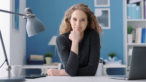 young woman sitting at desk and posing - Photo, image