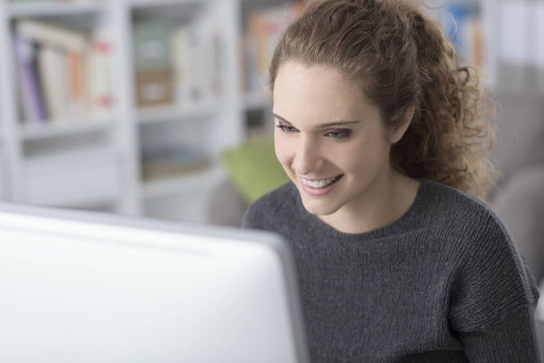 Молодая красивая женщина подключается к своему компьютеру
 - Фото, изображение