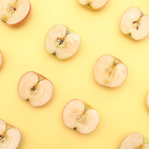 Achtergrond van gesneden in halve appels op gele achtergrond - Foto, afbeelding