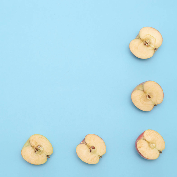 Background of cut in half apples on blue background - Fotoğraf, Görsel