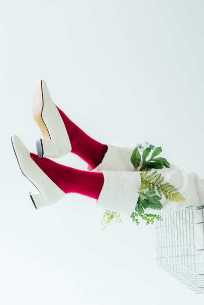 cropped view of woman in white pants with green leaves and stylish shoes isolated on white - 写真・画像