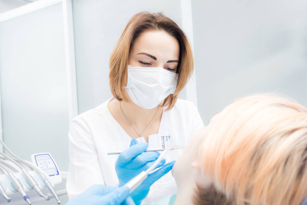 Young beautiful woman dentist treats teeth to woman patient - Fotografie, Obrázek