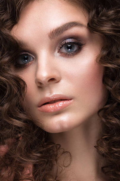 Beautiful brunette girl with a perfectly curly hair, and classic make-up. Beauty face. - Foto, imagen
