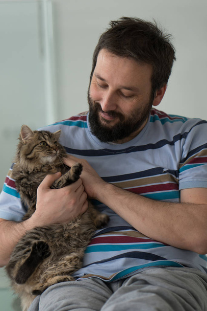 Adult man with cat at home - Фото, зображення