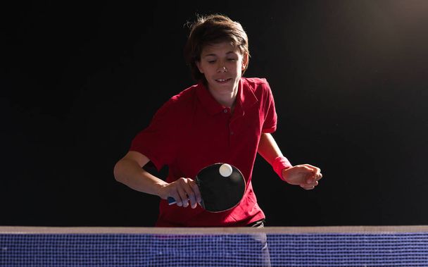 Νεαρό αγόρι παίζει πινγκ πονγκ πινγκ-πονγκ  - Φωτογραφία, εικόνα