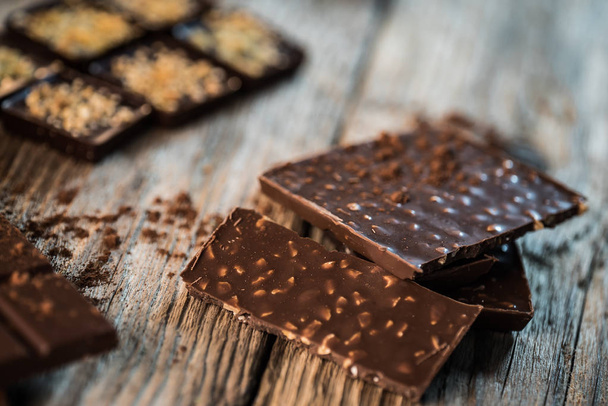 Delicious aromatic chocolate on wooden background - Foto, imagen