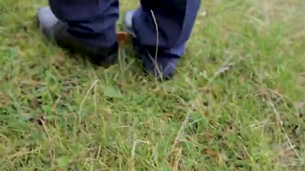 The feet of men in shoes go on the grass. - Felvétel, videó