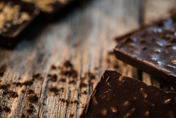 Delicious aromatic chocolate on wooden background - Foto, afbeelding