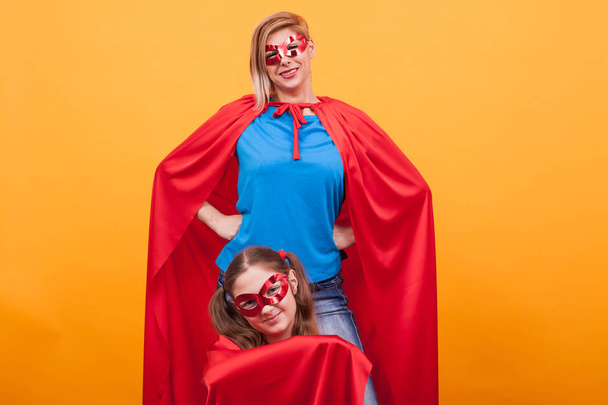 Mãe e filha brincando juntas vestidas como superheros
 - Foto, Imagem
