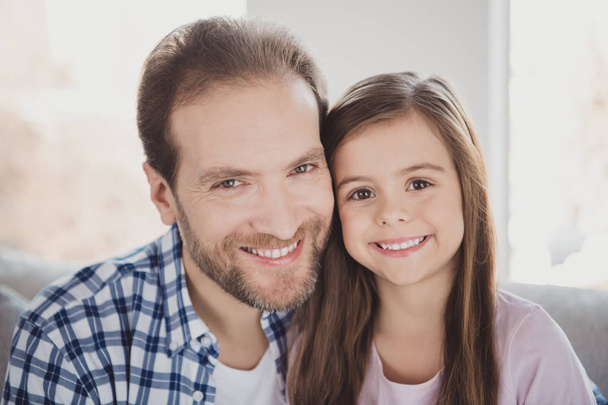 Close-up portrait of his he her she nice charming attractive cheerful cheery pre-teen girl dad daddy in light white interior room indoors - Foto, afbeelding