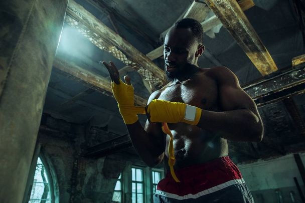 Afro American boxer is wrapping hands with bandage - Photo, image