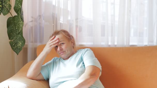 Elderly beautiful woman suffers from migraine - Záběry, video