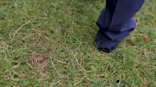 The feet of men in shoes go on the grass. - Filmmaterial, Video