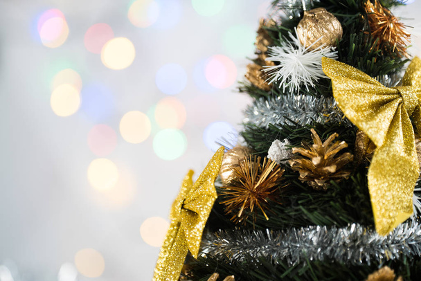 Small decorated Cristmas tree on festive bokeh background - Photo, Image