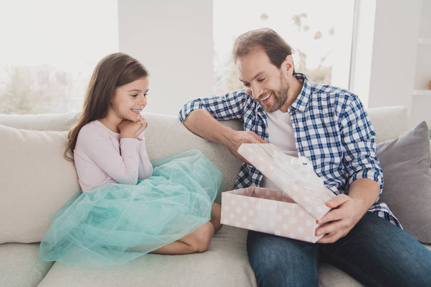 Close up photo little small she her girl taking he him his father togetherness sitting large present single daddy spend sunday morning celebrating worried wear checkered plaid shirt house cozy divan - Foto, Imagen