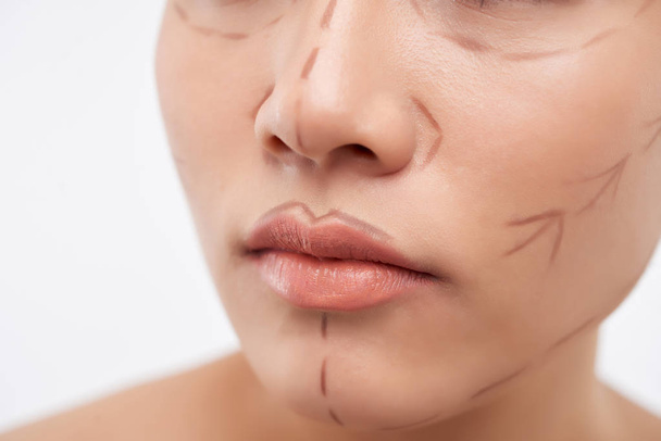 Közeli kép a női arc sebészeti vonalakkal - Fotó, kép