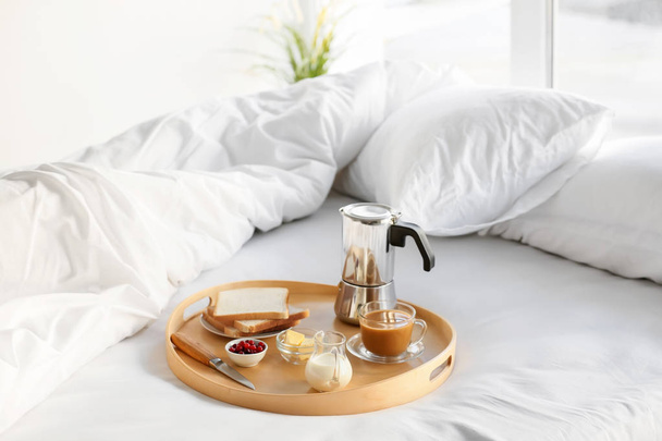 Tray with delicious breakfast on bed - Фото, зображення