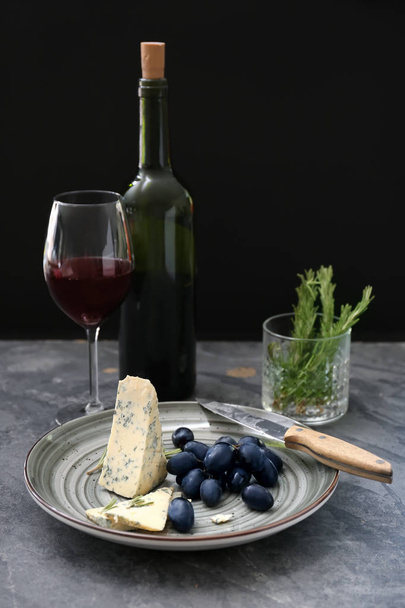 Ώριμα σταφύλια ζουμερά με τυρί και κόκκινο κρασί στο τραπέζι γκρι - Φωτογραφία, εικόνα
