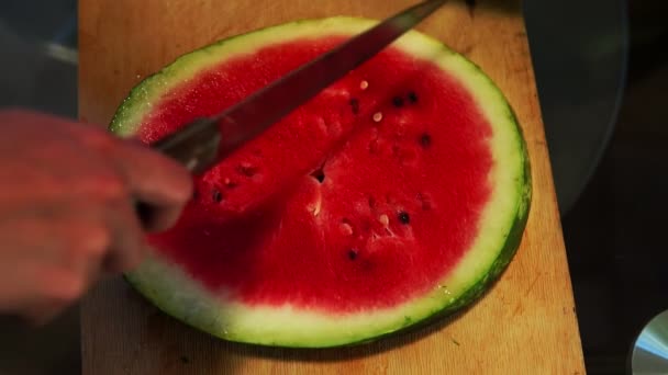 Corte fatias de melancia ao meio com uma faca
 - Filmagem, Vídeo