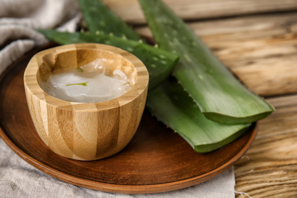 Bowl with aloe vera on wooden table - Foto, imagen