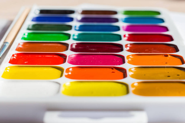Multi-colored bright Watercolor paints on a table close up - Фото, изображение