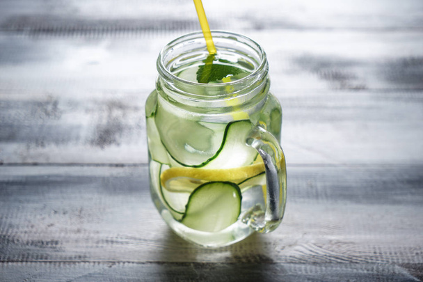 Mason jar of fresh cucumber water on wooden table - Foto, Bild