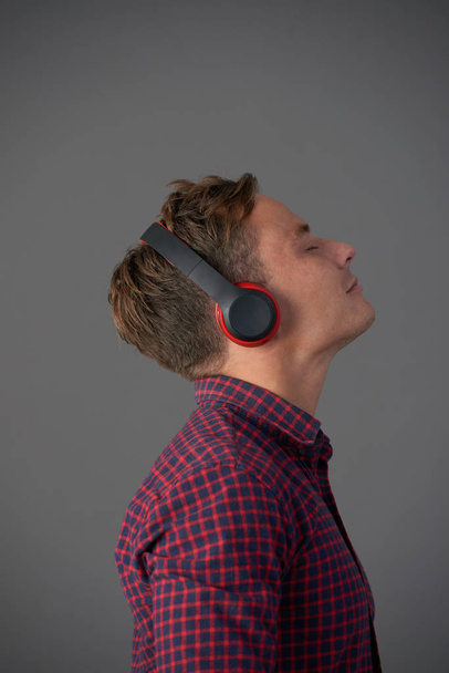 Молодий чоловік насолоджується чудовою музикою у своїх навушниках
 - Фото, зображення