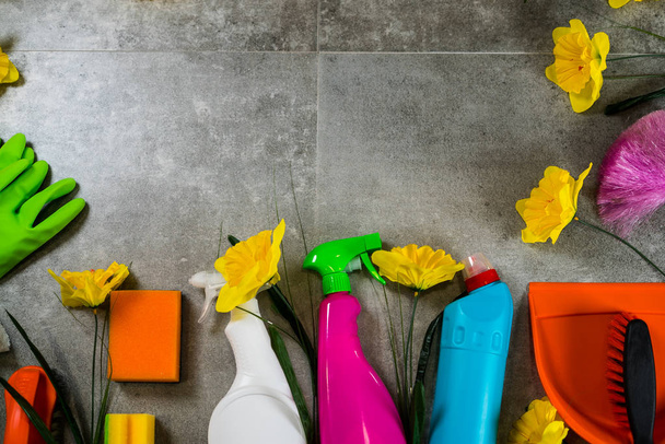 Conceito de limpeza doméstica. Quadro de vários produtos de limpeza e flores amarelas, lugar para tipografia
 - Foto, Imagem