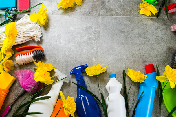 Koncepcja sprzątanie domu. Rama różne produkty czyszczące i żółte kwiaty, miejsce dla typografii - Zdjęcie, obraz