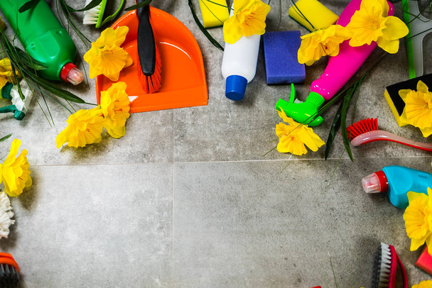 Home cleaning concept. Frame of various Cleaning Products and yellow flowers, place for typography - Photo, Image