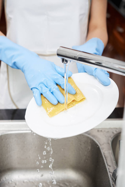 Mani di casalinga lavare i piatti sott'acqua
 - Foto, immagini
