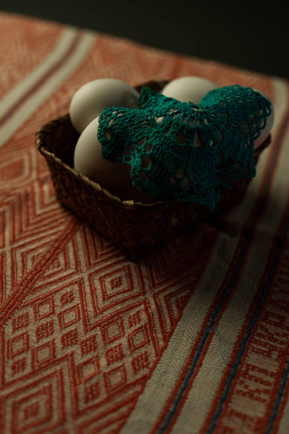 White chicken eggs, on decorative fabric, and in a beautiful basket, preparation for Easter - Фото, зображення