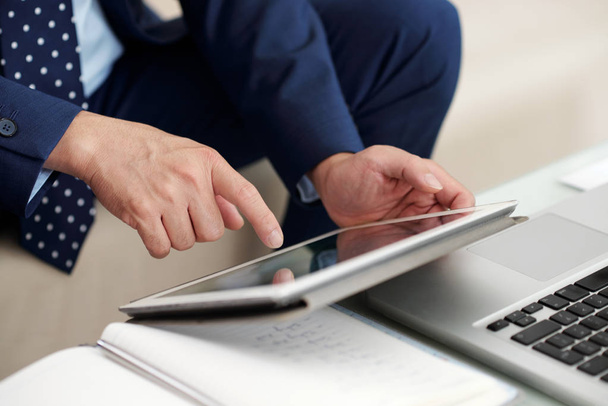 Hands of business executive using application on tablet computer - Fotó, kép