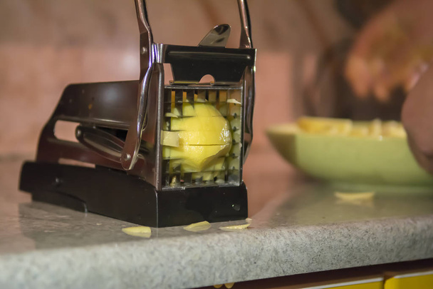 Ranskalaiset ranskalaiset leikkuukone, manuaalinen peruna leikkuri viipale. Prosessi ruoanlaitto ranskalaisia perunoita
 - Valokuva, kuva