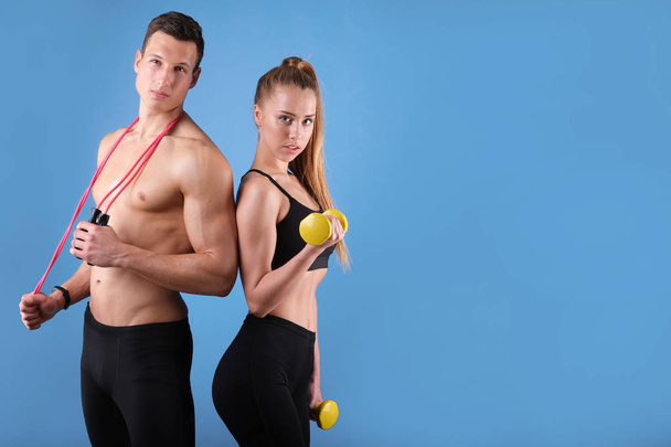 Fitness young man and woman isolated on blue background. - Photo, image