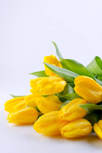 Ramo de hermosas flores de tulipán amarillo sobre fondo blanco. Tarjeta de felicitación. Copiar espacio
. - Foto, imagen