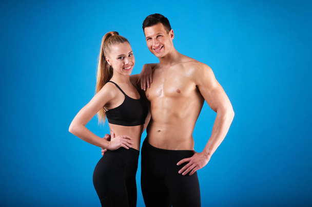 Fitness young man and woman isolated on blue background. - Foto, Bild