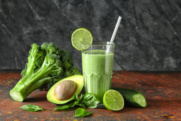 Bicchiere di frullato verde saporito e ingredienti su tavolo a colori
 - Foto, immagini